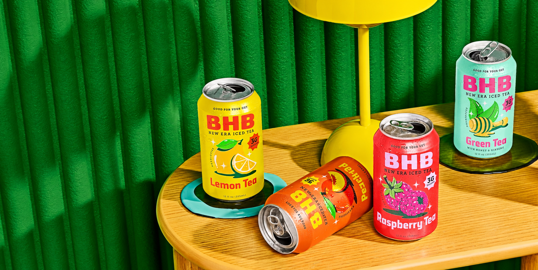 Colorful BHB iced tea cans on a sunny yellow table